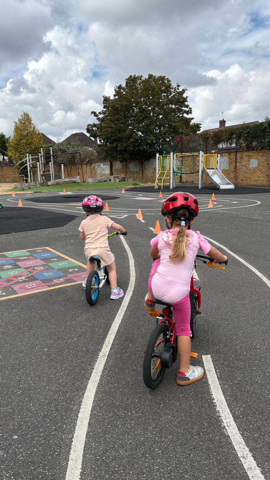 Children riding balance bikes at the park